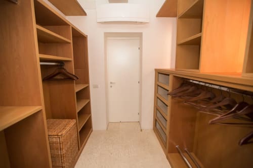 Ampio guardaroba con scaffali in legno, appendiabiti e cassetti presso Petra Apartments Roma