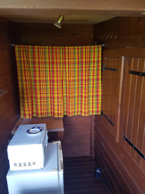 Intérieur du gîte Les Hauts De Deshaies avec lave-linge et rideau écossais coloré à Deshaies, Guadeloupe