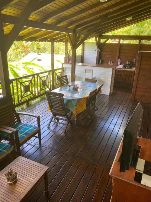 Appartement avec terrasse couverte aux Hauts de Deshaïes, coin repas, cuisine et vue tropicale sur la mer