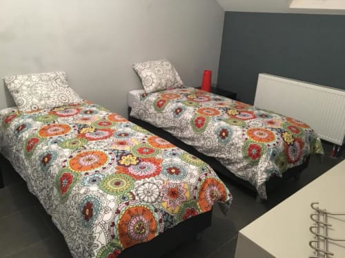 Duas camas de solteiro com roupa de cama floral colorida no Apartamento Courcelles, Bélgica