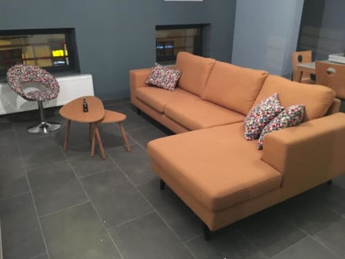 Sala de estar moderna com sofá seccional laranja, almofadas coloridas, mesa lateral de madeira e luminária de piso em Courcelles