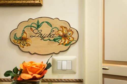 Cartello decorativo in legno con scritto 'Layla' e fiori gialli nella Suite Layla del Dormire Assisi B&B ad Assisi