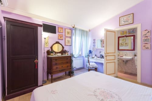 Camera lavanda con comò in legno, TV e bagno en-suite presso il B&B Dormire Assisi ad Assisi