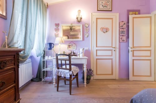 Affascinante camera da letto viola presso il Dormire Assisi B&B di Assisi, Italia, con porte in legno, scrivania e arredamento vintage