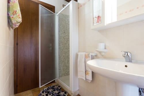 Bagno moderno con doccia, lavabo bianco e piastrelle al Dormire Assisi B&B di Assisi