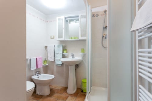 Bagno moderno nel B&B Assisi con lavabo a colonna, doccia, wc e dettagli verdi