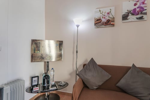 Cozy sitting area in Suite T1 at Armação Beach Residences with brown sofa, gray pillows, and ambient lighting in Armação de