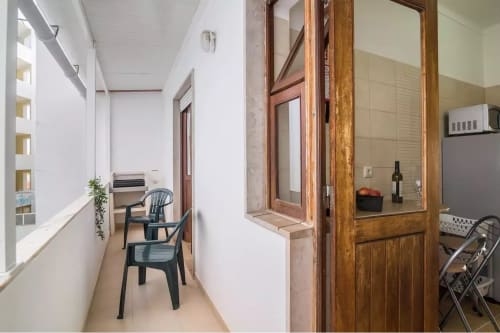 Bright hallway in Armação Beach Residences apartment with wooden door, sitting area, kitchenette, and tiled walls