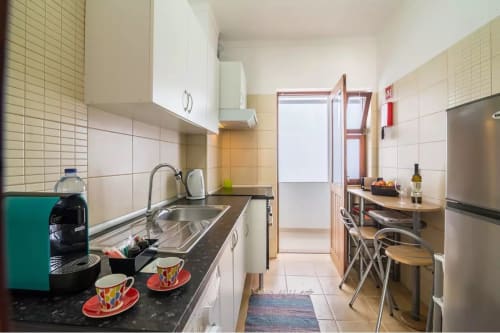 Modern kitchen in Armação Beach Residences apartment with dining area, stainless steel appliances, and city views in Armação