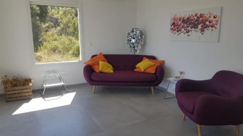 Salon moderne à la Résidence Lésia à Corbara avec canapé bourgogne, fauteuil, coussins jaunes et lumière naturelle