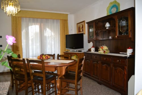 Salle à manger Double Moon avec table en bois, chaises, téléviseur et buffet traditionnel à Affittacamere Al Mare, Torre