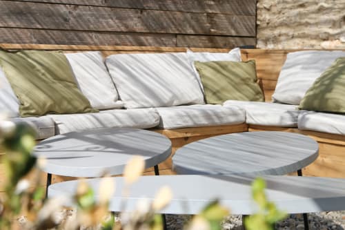 Salon de détente extérieur à Mas Lafleur à Châteaurenard avec canapé-modules bois, coussins blancs et oreillers verts