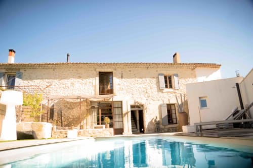 Hôtel Mas Lafleur à Châteaurenard avec façade en pierre, piscine et cour dégagée sous ciel bleu