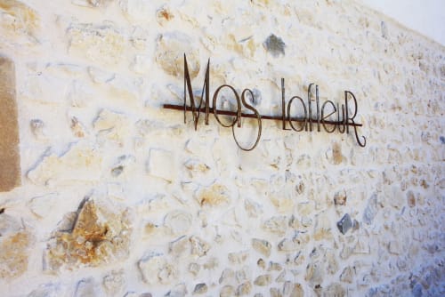 Enseigne métallique Mas Lafleur sur un mur en pierre rustique à Châteaurenard, France