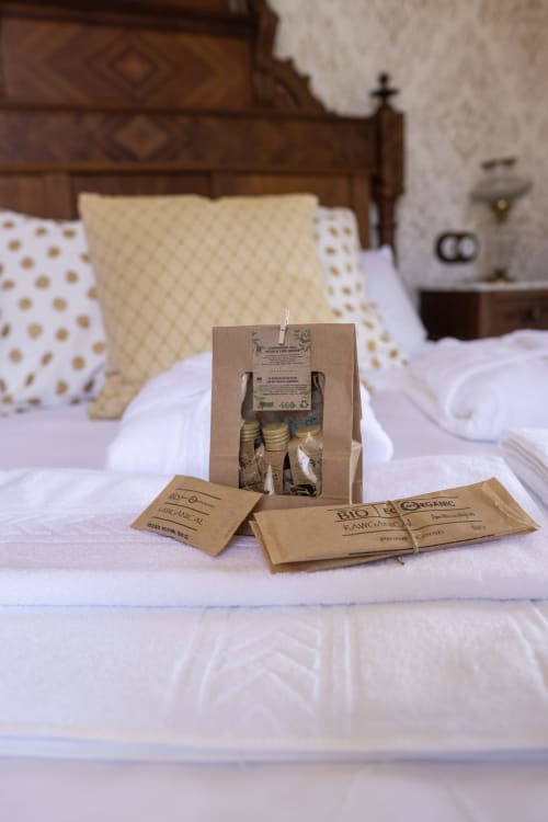 Eco-friendly toiletries and organic amenities on bed in El Palacio room at La Venta de Miyares hotel, Asturias