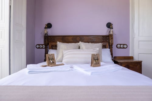 Dormitorio Suite Pintueles en La Venta de Miyares con cama de madera, ropa de cama blanca y paredes lavanda en Miyares, España