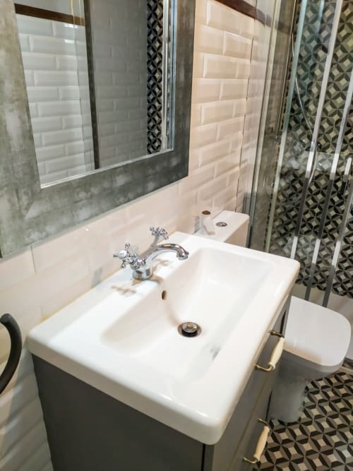 Moderno lavabo de baño con grifería cromada y espejo en la Suite Pintueles de La Venta de Miyares