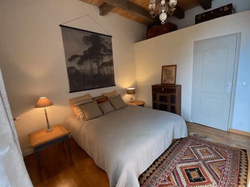 Chambre douillette aux Lumieres Du Causse B&B à Bellefont-La Rauze avec lit, poutres en bois et éclairage chaleureux