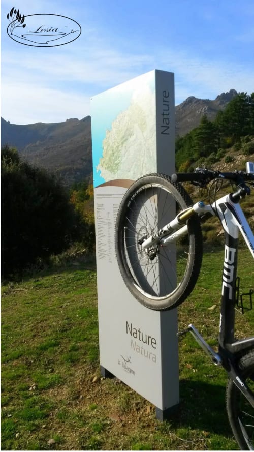 VTT appuyé contre l'enseigne Nature Natura à la Résidence Lésia à Corbara, France