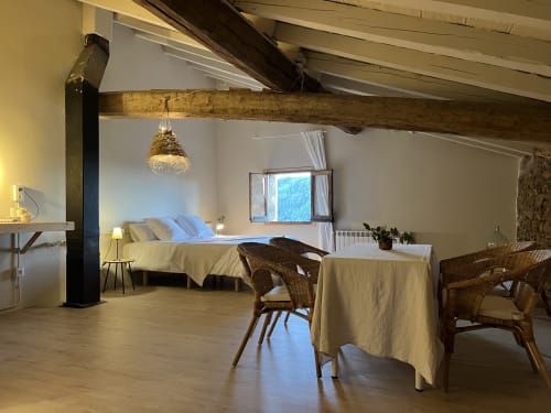 Espaciosa habitación LA GUINEU en Casa Tapiolas en Molló con vigas vistas, vistas a la montaña, cama, zona de comedor y encanto rústico