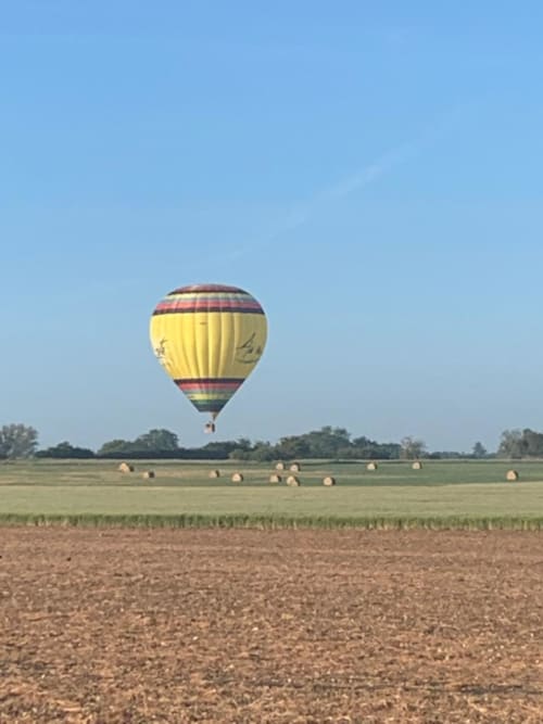 Mongolfière jaune survolant les terres agricoles de la vallée de la Loire près de l'Hôtel Cheverny La Vie Est Belle