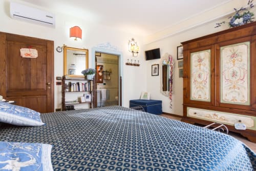 Camera spaziosa al Dormire Assisi B&B con letti singoli, armadio in legno, pavimento decorato e vista sulla città