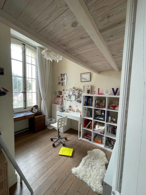 Chambre mansardée lumineuse au gîte Campagne d'Albert à Marseille avec poutres apparentes, bureau, étagères et vue sur jardin