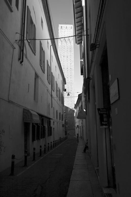 Narrow cobblestone alley in Bologna leading to historic tower, L'Appartamento Giusto nearby