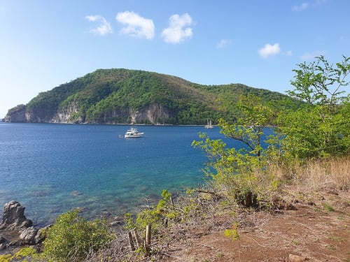 Vue côtière pittoresque avec voiliers mouillés et île forestière verdoyante près de la Résidence Les 2 Moulins au Moule, Guadeloupe