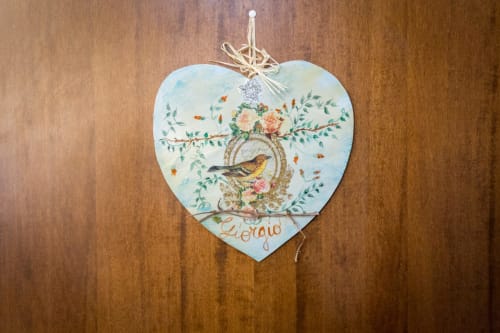 Insegna in legno a forma di cuore con decorazione floreale e uccello, ornamento appeso presso la Dormire Assisi B&B ad Assisi, Italia
