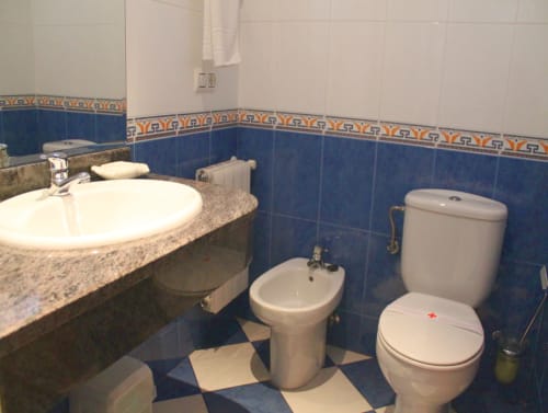 Banheiro moderno do hotel Turismo en Sanabria em Vigo, Zamora com azulejos azuis, pia, bidê e vaso sanitário