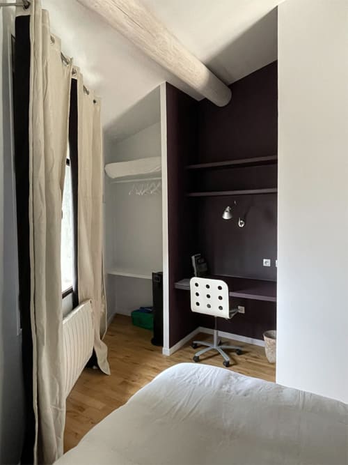 Chambre moderne à Campagne d'Albert Marseille avec espace de travail, mur d'accent sombre, parquet et literie blanche