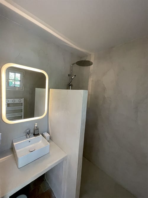 Salle de bain moderne du Campagne d'Albert BnB à Marseille avec miroir lumineux, lavabo blanc et douche pluie