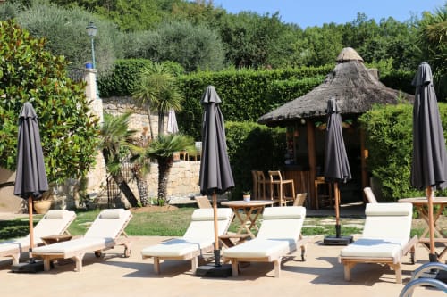 Blick auf die Sonnenliegen am Pool des Loup Castel mit der Tiki-Bar dahinter – provenzalische Sommergelassenheit