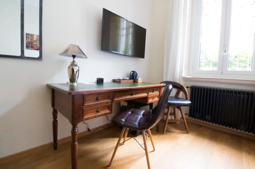 Moderna scrivania e sedia in camera Milano con TV, lampada e arredi in legno presso Porta Tosa B&B