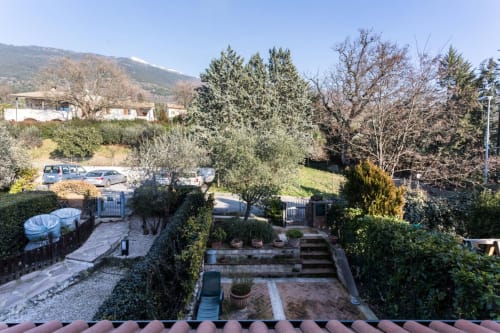 Countryside garden view with terracotta patio, olive trees, and Assisi mountains at Dormire Assisi apartment
