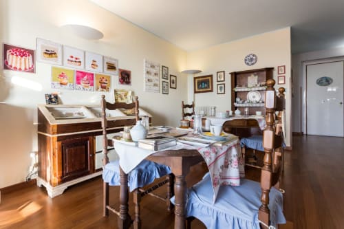Charming vintage-style dining room at Dormire Assisi with wooden furniture, blue accents, and cake artwork in Assisi