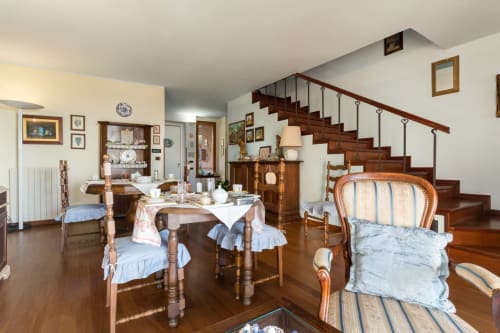 Spacious Assisi apartment with dining area, wooden staircase, and traditional furnishings overlooking garden