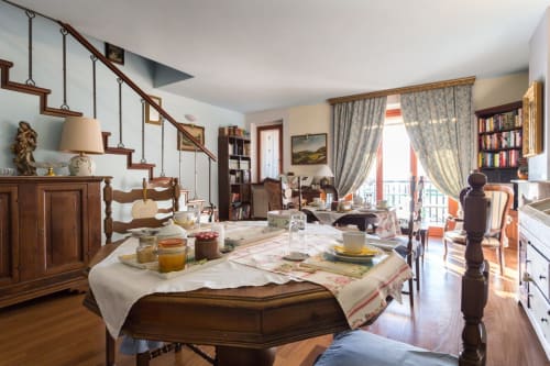 Cozy apartment dining area with wooden furniture, vintage decor, and garden views in Assisi, Italy