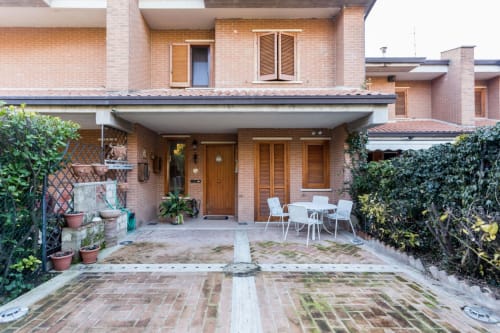Brick terrace with dining furniture and potted plants at Dormire Assisi, a garden-view apartment in Assisi, Italy