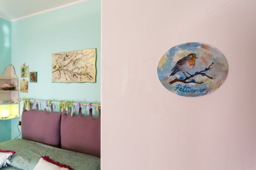 Charming bedroom at Dormire Assisi in Assisi with turquoise walls, bird artwork, and garden view decor