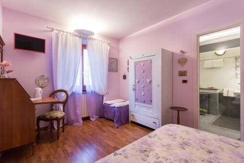 Camera rosa presso Dormire Assisi B&B ad Assisi, Italia, con TV, scrivania, armadio e bagno moderno