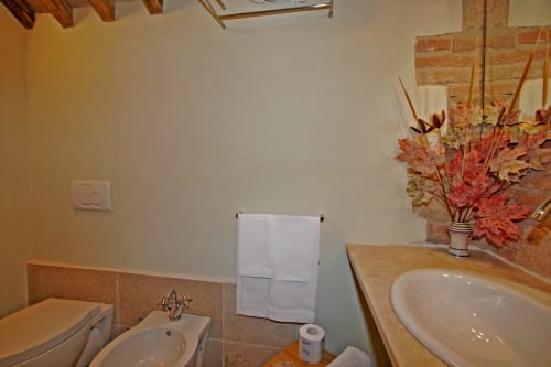 Bagno della Locanda del Vino Nobile a Montepulciano con doppio lavabo, bidet e decorazioni floreali autunnali