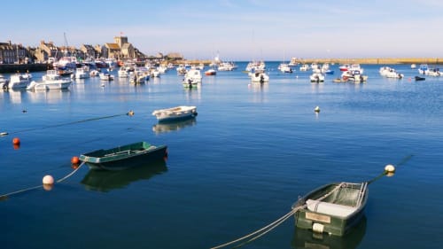 Charmant port côtier du Vast en France avec bateaux amarrés et bâtiments historiques en bord de mer