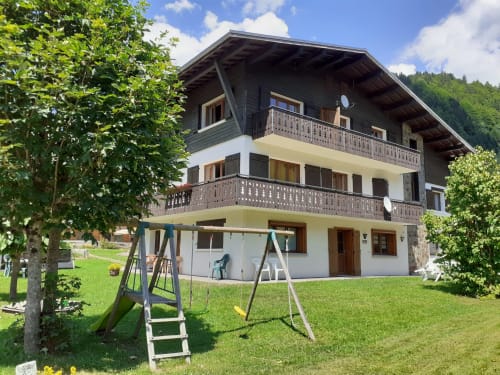 Chalet Les Arcosses, gîte alpin avec pelouse verdoyante, balançoires et vue montagne à La Giettaz