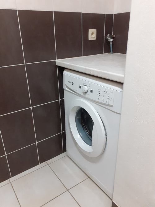 Lave-linge blanc avec plan de travail-évier dans la salle de bains moderne du Chalet Les Arcosses, La Giettaz