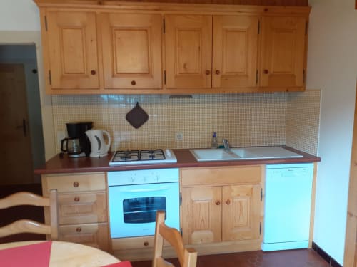 Cuisine de l'appartement Chalet Les Arcosses à La Giettaz avec placards en bois, cuisinière à gaz et évier