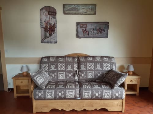 Chambre cosy au Chalet Les Arcosses à La Giettaz avec futon en bois, décoration montagnarde et art mural alpin