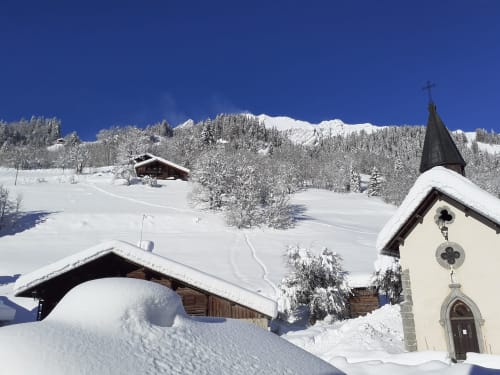 Village alpin enneigé avec chapelle au Chalet Les Arcosses, La Giettaz, paysage glacé et montagnes