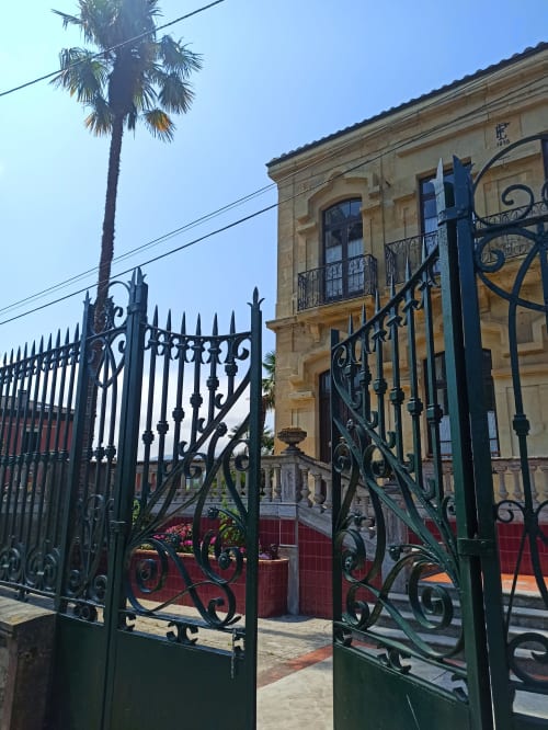 Ornate green wrought iron gates and colonial architecture at La Venta de Miyares in Piloña, Spain